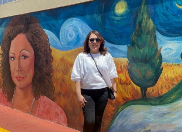 Emelyn Baldera posando en mural de Santiago.