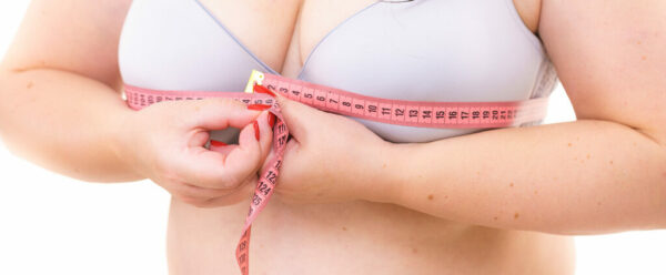 Woman measuring her chest breasts bust size