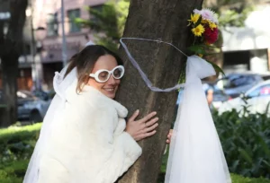 Fotografía de una mujer participando en una "boda" con un árbol, en un parque en Ciudad de México (México).