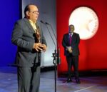 Chucky Acosta al recibir su galardon. Observa, Wilfrido Vargas.