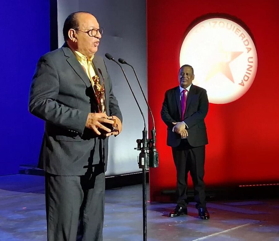 Chucky Acosta al recibir su galardon. Observa, Wilfrido Vargas.