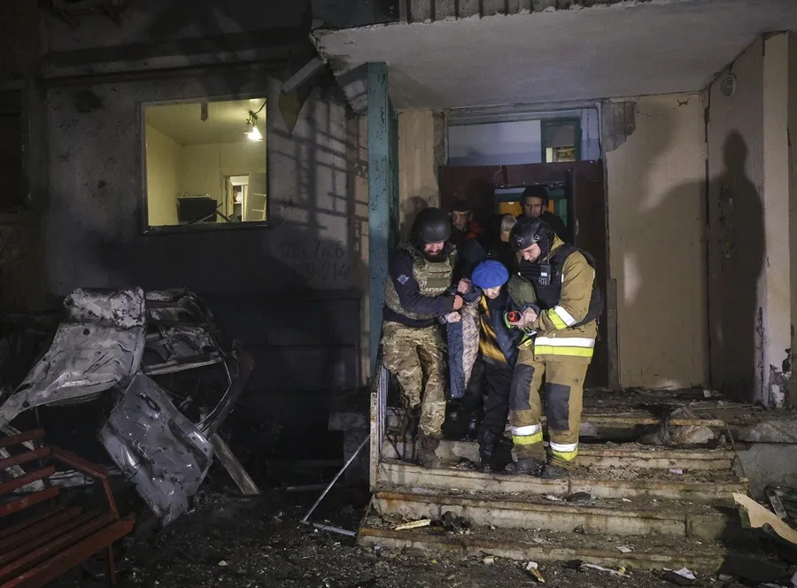 Rescatistas ucranianos evacúan a una persona tras un ataque ruso contra un edificio residencial en Járkov, noreste de Ucrania, este 19 de noviembre.