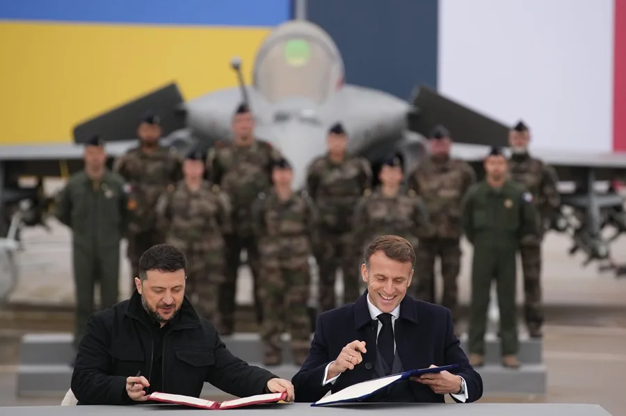 El presidente francés, Emmanuel Macron (d) y el ucraniano Volodimir Zelenski (i) en la firma de un acuerdo militar en la base aérea de Villacoublay, cerca de París.