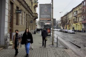 Vecinos de Leópolis pasan por delante de un anuncio de reclutamiento militar.