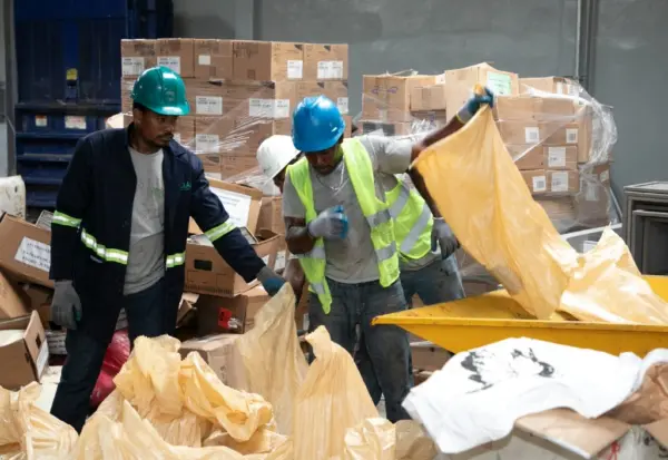 Trabajadores manipulan productos decomisados por Proconsumidor para su destrucción. archivo