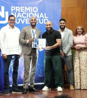 El joven líder comunitario Juan River Veloz Reyes recibe su reconocimiento.