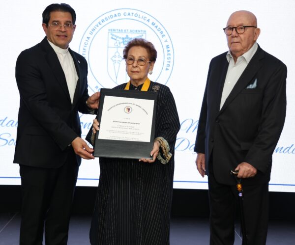 El rector de la PUCMM, Secilio Espinal; Xiomara Dájer de Menéndez y su esposo, Ramón Antonio Menéndez, durante el acto de reconocimiento.