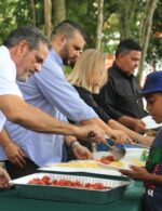 El Comisionado  Junior Noboa sirve alimentos a los atletas.