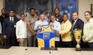 El presidente  del Banreservas, Leonardo Aguilera  recibe  chaqueta  del Mauricio Báez, de parte de Leo Corporán.       Externa