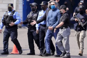 Fotografía de archivo del expresidente hondureño Juan Orlando Hernández (c) el día de su extradición a Estados Unidos en 2022.