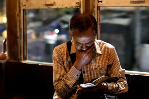 Un hombre consulta su teléfono móvil en Calcuta.