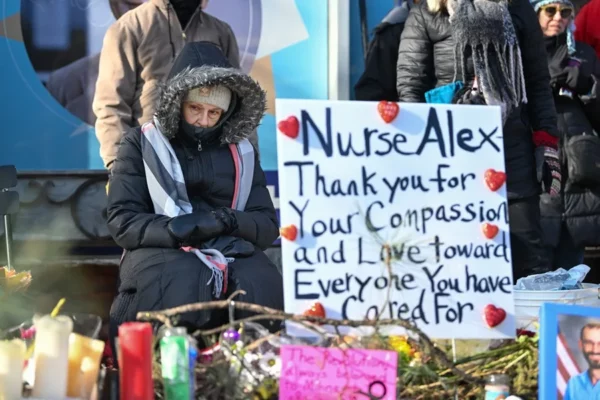 Una mujer rinde homenaje al enfermero Alex Pretti en un monumento improvisado en el sur de Mineápolis, Minnesota, EE. UU.
