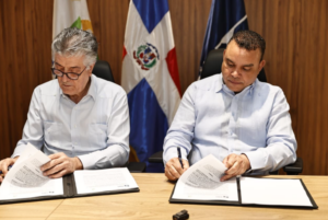 El doctor Julio Ladrón y Roberto Santana Sánchez firmando un convenio de colaboración interinstitucional.