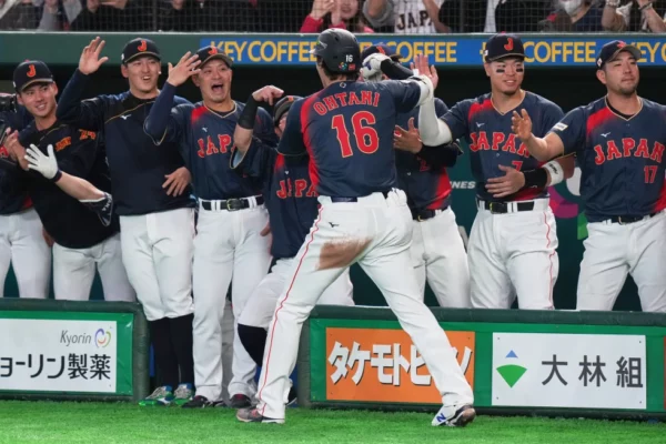 Shohei Ohtani (de espaldas) celebra con sus compañeros de Japón luego de batear un jonrón en el Clásico Mundial de béisbol, el viernes 6 de marzo de 2026, en Tokio. (AP Foto/Eugene Hoshiko)