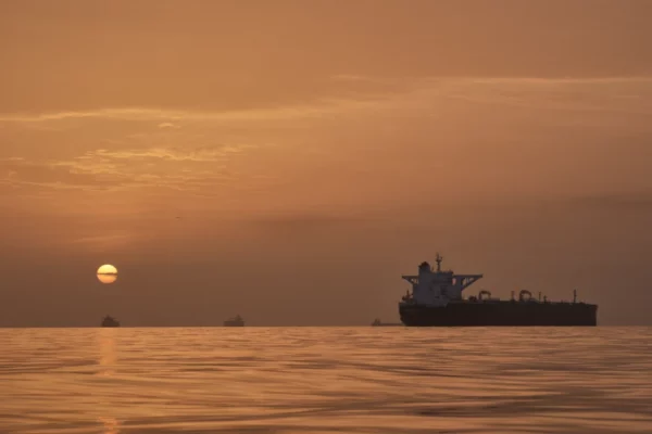 El sol se levanta detrás de varios buques petroleros anclados en el estrecho de Ormuz, frente a la costa de la isla Qeshm, Irán, el sábado 18 de abril de 2026