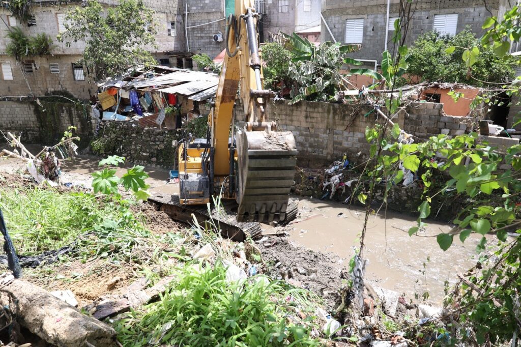 Equipos se encontraban este jueves removiendo escombros y basuras en el río Lebrón en Nuevo Amanecer, luego de las inundaciones. Alexis Monegro. 