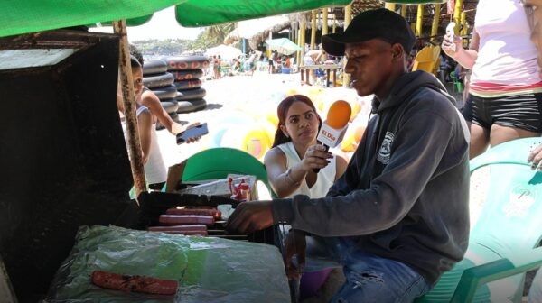 Joven vendiendo pinchos calientes en Playa Najayo.