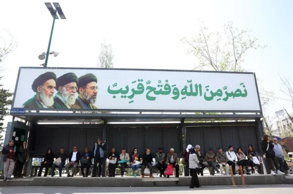 Una marquesina de autobús en una calle de Teherán con la imagen de los últimos líderes espirituales de Irán.