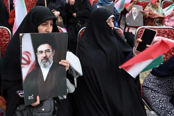 Una mujer iraní vestida con un chador negro sostiene un cartel del líder supremo iraní, el ayatolá Mojtaba Khamenei. EFE/EPA/Abedin Taherkenareh