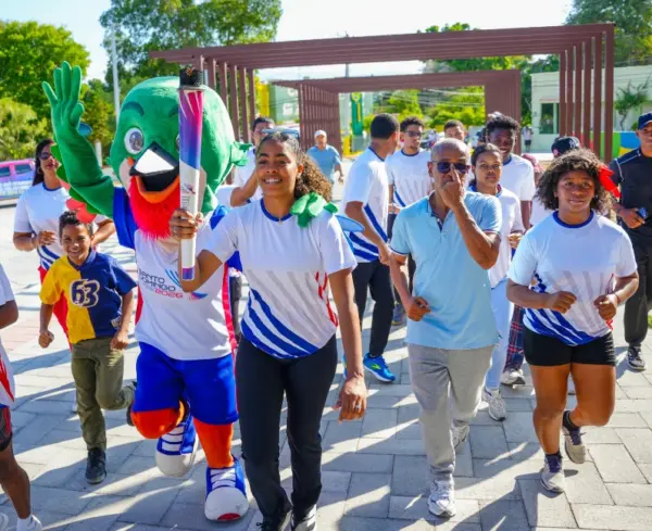 Atleta de voleibol, Yarianna Torres, porta la antorcha centroamericana y del Caribe, en el recorrido de Neyba.