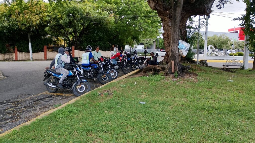 Motoconchos frente a supermercado en Los Ríos esperando por pasajeros.