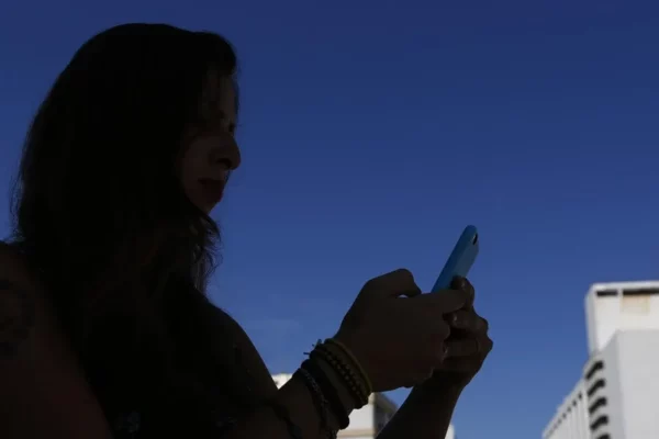 Una mujer mira a su teléfono móvil.