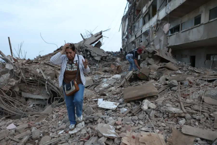 Dos mujeres caminan entre los escombros de edificios dañados por los sismos Venezuela