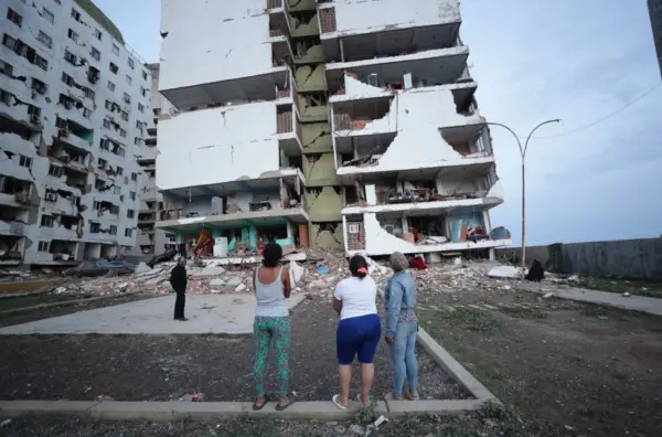 Personas contemplan estructura devastada por el doble sismo ocurrido en Venezuela. Fuente externa.