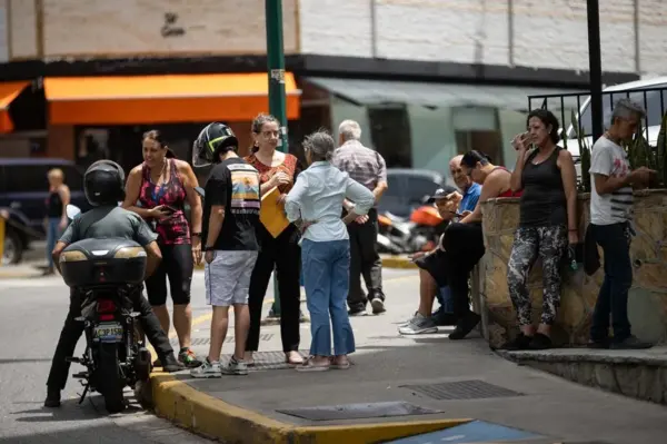 Personas esperan afuera de sus viviendas, este 10 de julio de 2026, luego de un sismo de magnitud 3,9, en Caracas (Venezuela).