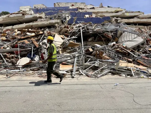 Un hombre camina frente a escombros de una edificación derrumbada por terremotos en La Guaira (Venezuela). EFE