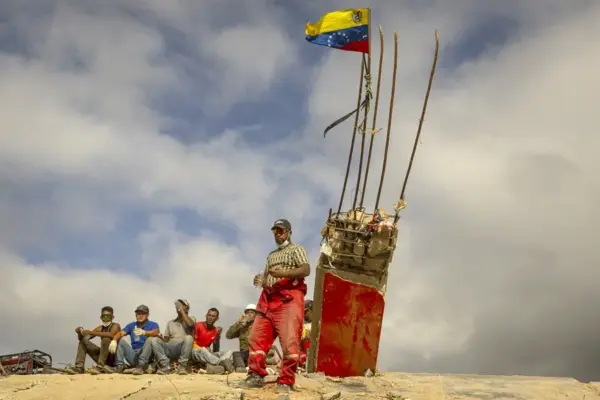 Fotografía del 17 de julio del 2026 que muestra personas descansando durante un recorrido para acompañar con oraciones a familiares, voluntarios y rescatistas que continúan las labores de recuperación de cuerpos atrapados bajo los escombros tras los terremotos del pasado 24 de junio en Venezuela. EFE