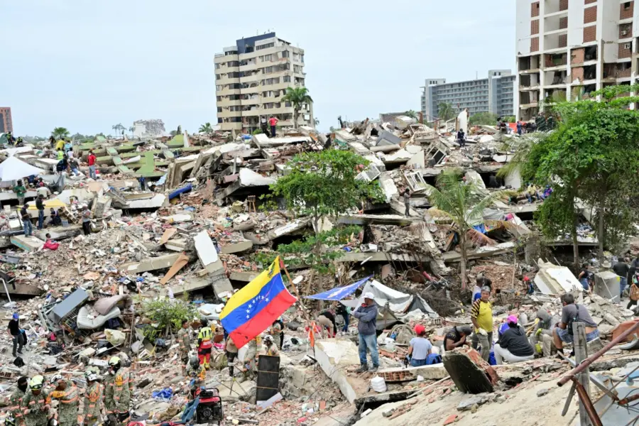 Miembros de una unidad de rescate del Ejército mexicano y voluntarios trabajan entre los escombros de edificios derrumbados.