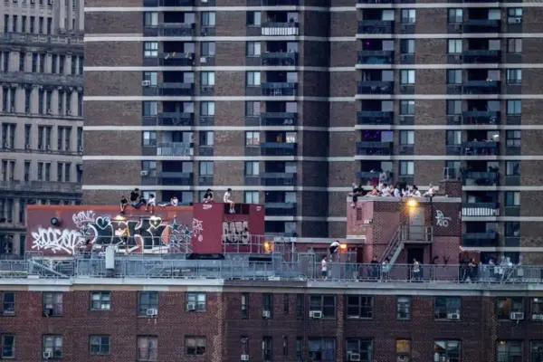 Residentes de la zona baja de Chinatown, frente al río East, observan desde un balcón el espectáculo de fuegos artificiales con motivo del 250.º aniversario de la Independencia en Nueva York, Estados Unidos, el 4 de julio de 2026. EFE/EPA/Laura Brett