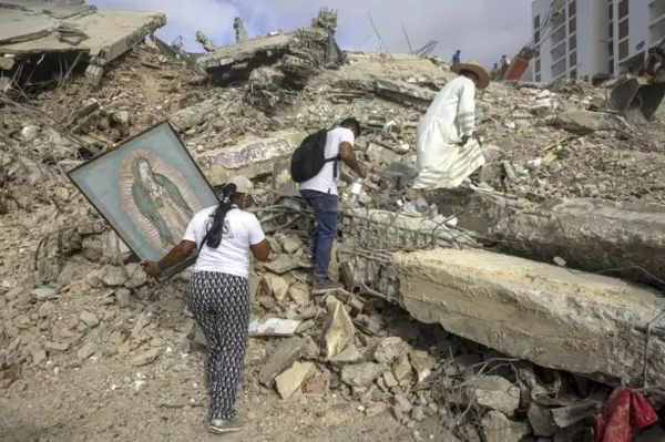 Fotografía del 17 de julio del 2026 que muestra al sacerdote Omar Pérez Gabino (d) caminando durante un recorrido para acompañar con oraciones a familiares, voluntarios y rescatistas que continúan las labores de recuperación de cuerpos atrapados bajo los escombros tras los terremotos en Venezuela. EFE/ Miguel Gutiérrez