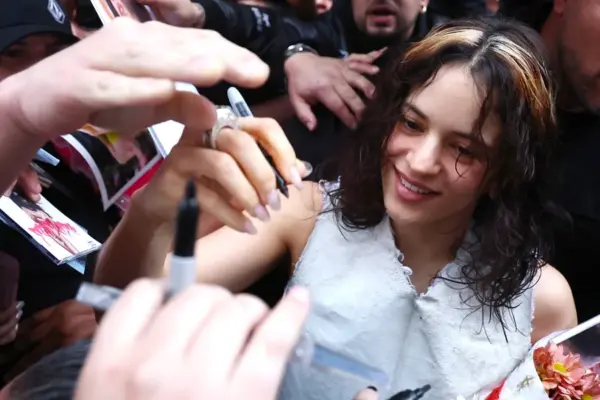 Fotografía de la cantante española Rosalía firmando autógrafos a sus seguidores.