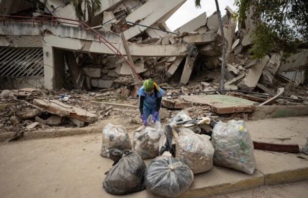 Voluntaria organiza  bolsas de basura en una calle durante el operativo de  limpieza.  efe