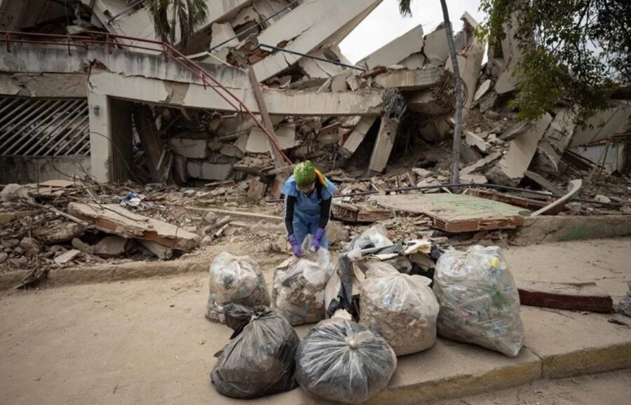 Voluntaria organiza  bolsas de basura en una calle durante el operativo de  limpieza.  efe