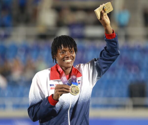 Marileidy Paulino muestra su medalla de oro y celebra bajo la lluvia tras imponerse en los 400 metros planos.  ffe