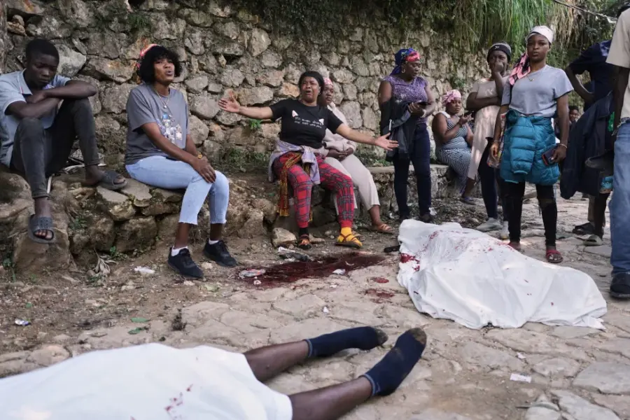 Varias personas se reúnen junto a los cuerpos de quienes, según dijeron, eran sus familiares y fueron asesinados en un ataque de pandillas en el barrio de Kenscoff, el lunes 24 de agosto de 2026, en Puerto Príncipe, Haití.