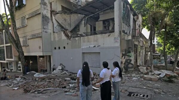 Personas contemplan estructura colapsada por terremoto en Colombia.