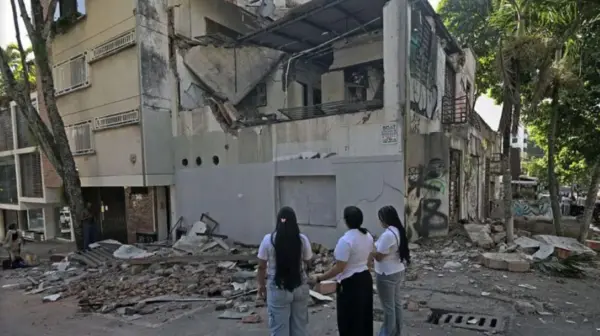 Personas contemplan estructura colapsada por terremoto en Colombia.