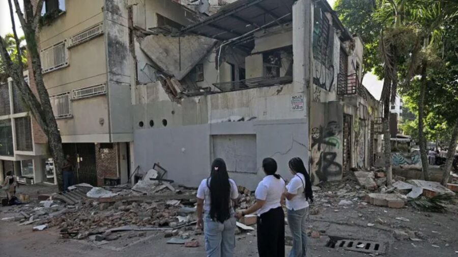 Personas contemplan estructura colapsada por terremoto en Colombia.