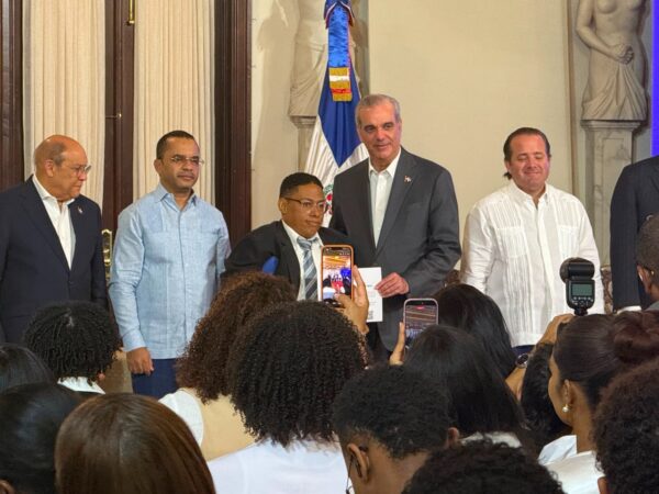 Presidente Abinader entrega beca a un beneficiario.