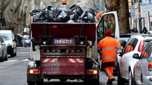 imagen ilustrativa muestra a un empleado de la empresa de recolección de basura de Roma, Ama, subiendo a su camión. AFP.