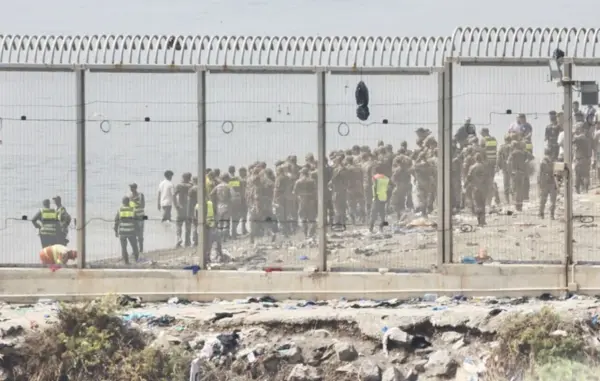Fuerzas auxiliares de Marruecos impiden la llegada al espigón de la playa del Tarajal que separa Ceuta de Marruecos.