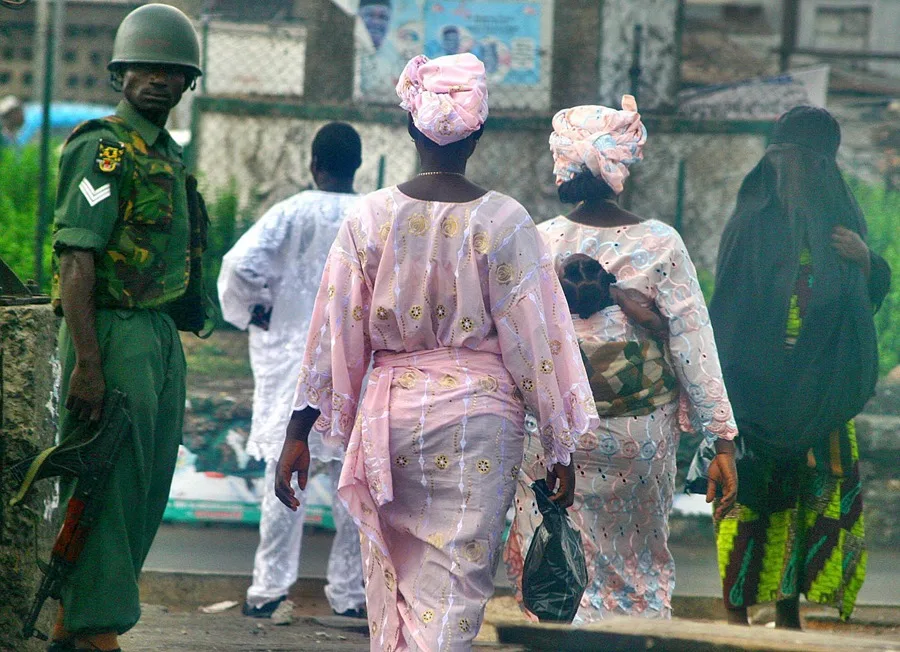 Mujeres nigerianas pasan al lado de unos soldados que patrullan en una calle de Ibadan, en el sudoeste de Nigeria, en una imagen de archivo.