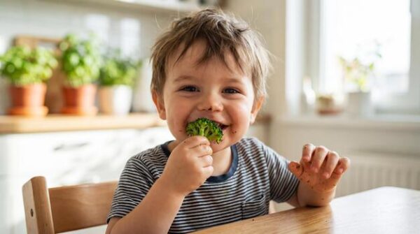 small-child-eating-broccoli-agriculture-and-healthy-food-concept-world-vegan-day-photo