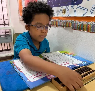Un niño utiliza el ábaco.