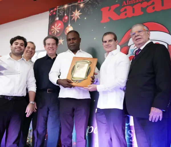 Rolando Sebelén, junto a sus hijos y nieto, entregan una placa de reconocimiento al empresario  Evaristo Parra, de Distribuidora Parra, durante el acto celebrado en Almacenes Karaka.