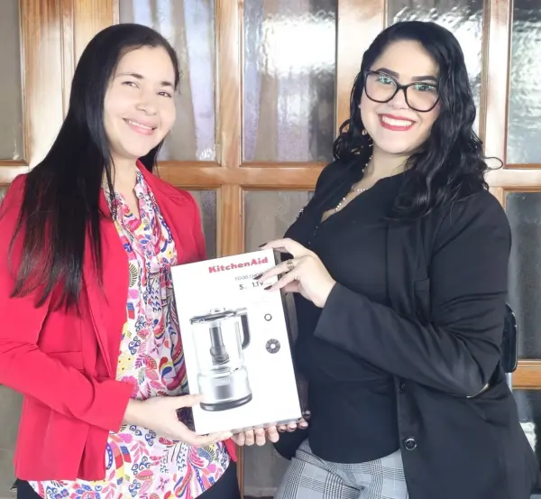 Greysy Ávila, encargada Administrativa de Gisef, entrega un procesador de alimentos a Isolina Pérez, ganadora del tercer premio.